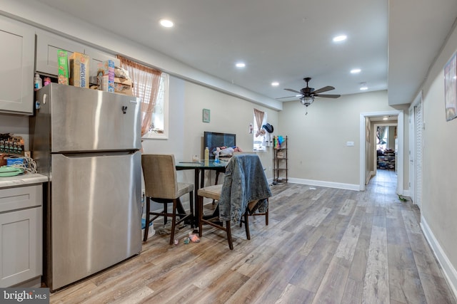 dining room with ceiling fan and light hardwood / wood-style flooring