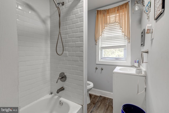 full bathroom with hardwood / wood-style flooring, vanity, toilet, and tiled shower / bath