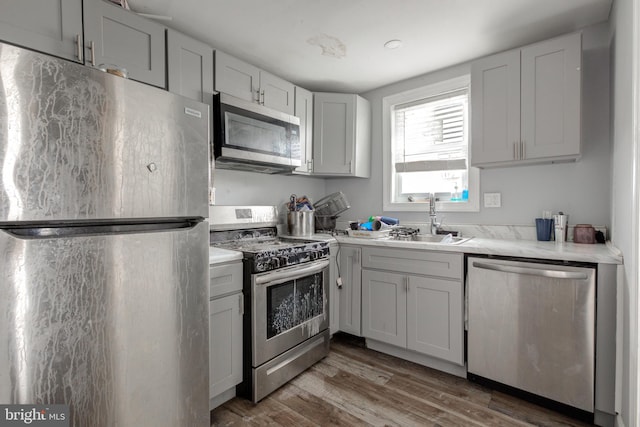 kitchen with white cabinets, appliances with stainless steel finishes, dark wood-type flooring, and sink