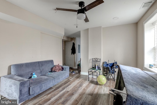 living room featuring wood-type flooring and ceiling fan