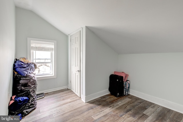 bonus room featuring light hardwood / wood-style floors, a baseboard radiator, and lofted ceiling