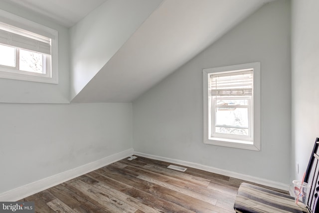 bonus room with plenty of natural light, lofted ceiling, and hardwood / wood-style flooring