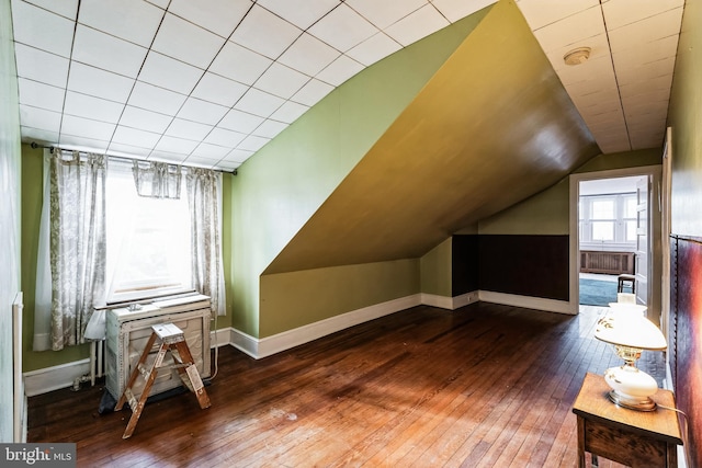 bonus room with vaulted ceiling and dark wood-type flooring