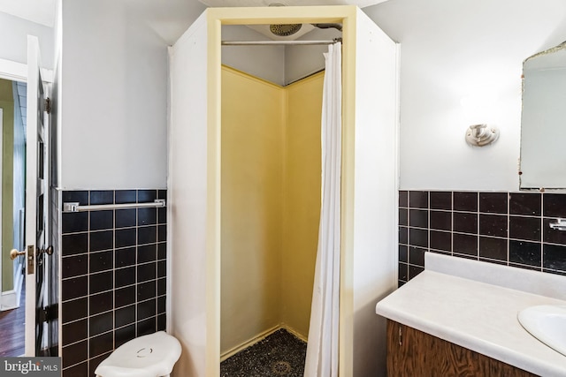 bathroom featuring vanity, wood-type flooring, and tile walls