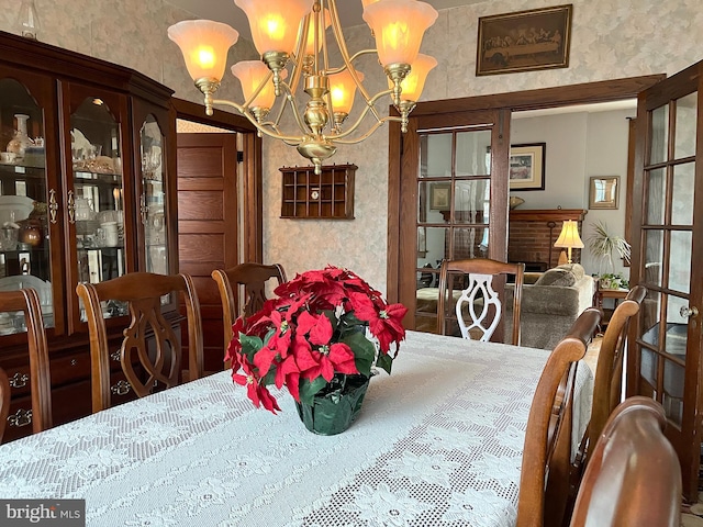 dining space with french doors and a notable chandelier