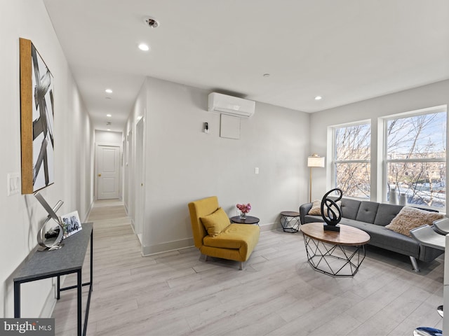 living room featuring an AC wall unit and light hardwood / wood-style flooring