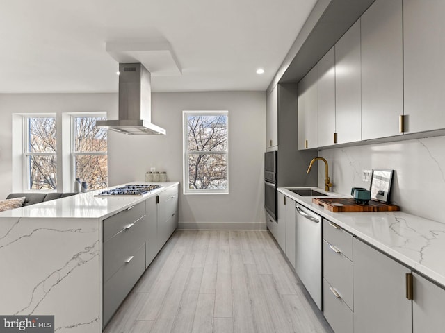 kitchen with a healthy amount of sunlight, gray cabinets, wall chimney exhaust hood, and sink