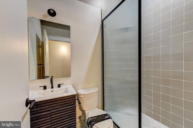 bathroom featuring vanity, toilet, and a tile shower