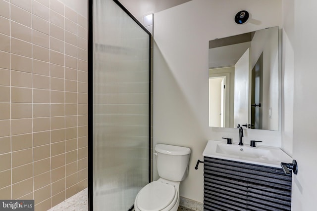 bathroom featuring vanity, toilet, and tiled shower