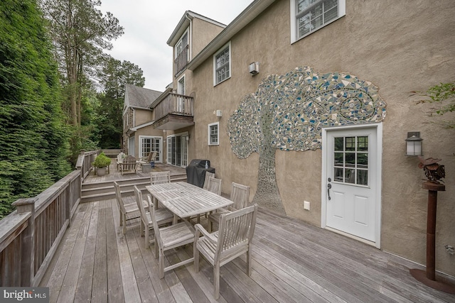 wooden deck with outdoor dining area and a grill