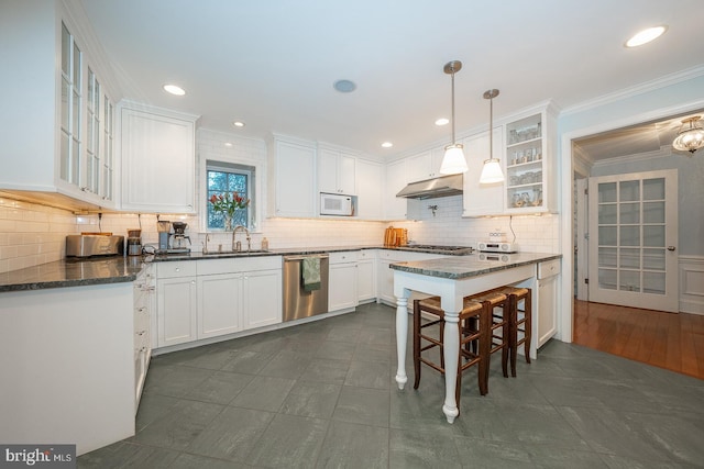 kitchen with appliances with stainless steel finishes, glass insert cabinets, and white cabinets