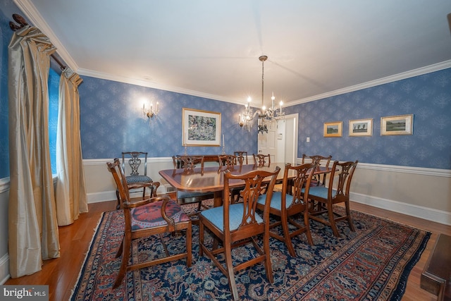 dining space with wood finished floors, wainscoting, and wallpapered walls