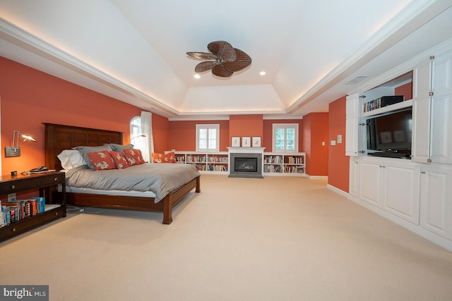 bedroom with recessed lighting, a fireplace, a raised ceiling, and light colored carpet