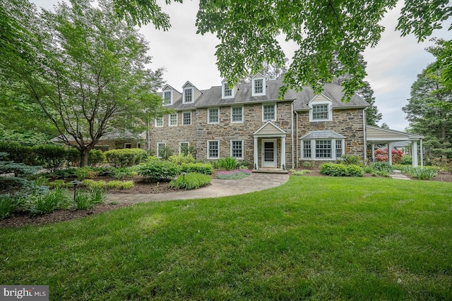 view of front facade featuring stone siding and a front lawn