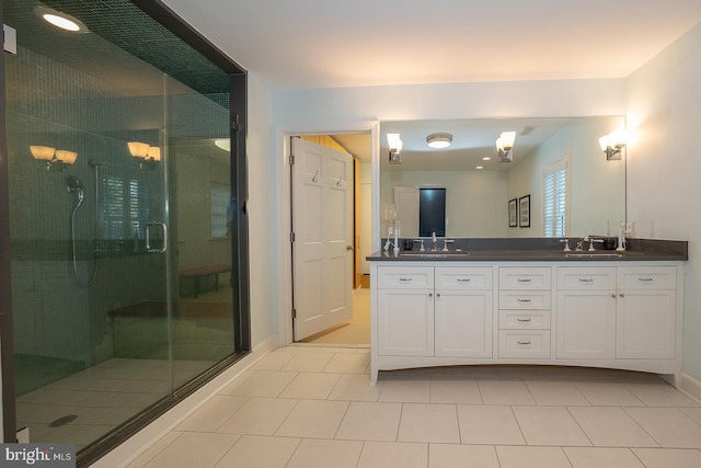 bathroom featuring baseboards, double vanity, a sink, and a shower stall