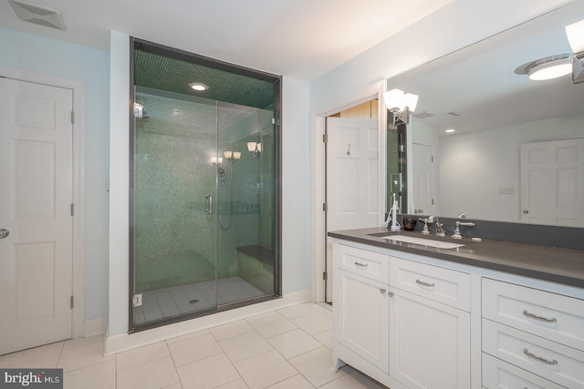 bathroom with a stall shower, tile patterned floors, visible vents, and vanity