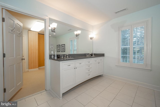 full bath featuring double vanity, baseboards, visible vents, tile patterned floors, and a sink