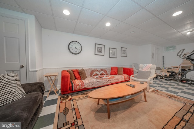 living area featuring a paneled ceiling, recessed lighting, and wainscoting