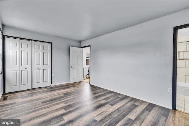 unfurnished bedroom with a closet and dark wood-type flooring