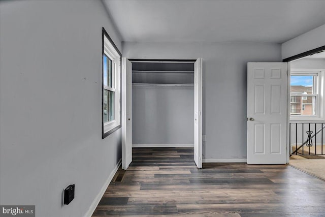 unfurnished bedroom featuring a closet and dark hardwood / wood-style flooring