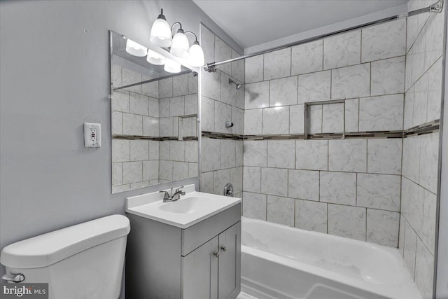 full bathroom featuring vanity, tiled shower / bath combo, and toilet