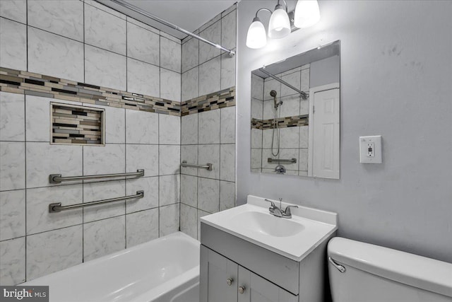 full bathroom featuring vanity, tiled shower / bath combo, and toilet