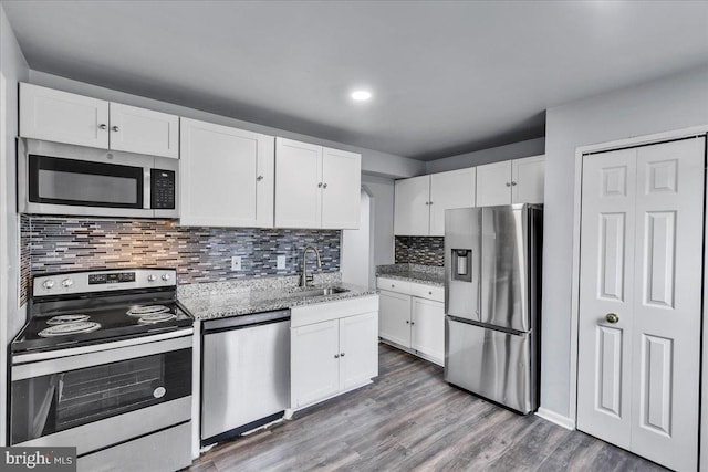 kitchen featuring decorative backsplash, sink, white cabinets, and appliances with stainless steel finishes