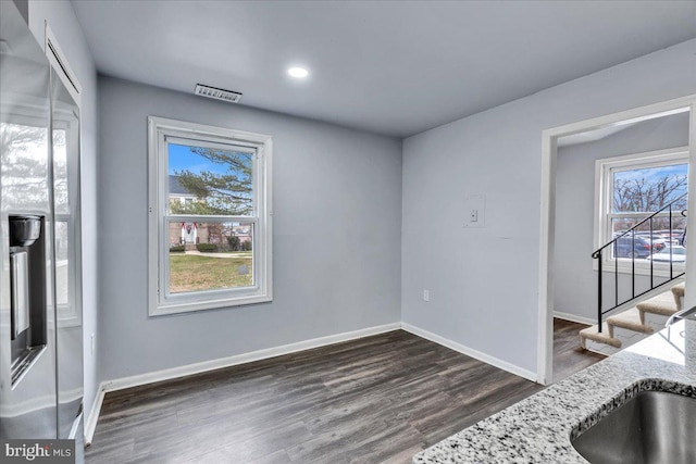 unfurnished dining area with sink, a healthy amount of sunlight, and dark hardwood / wood-style floors