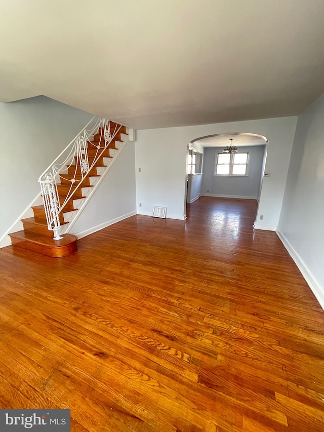 unfurnished living room featuring hardwood / wood-style floors and a chandelier