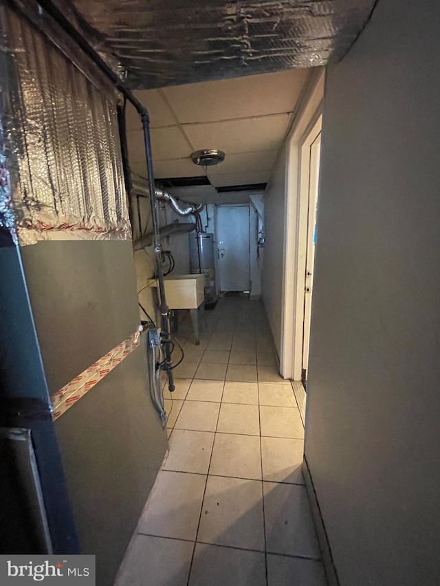 hallway with light tile patterned floors and water heater