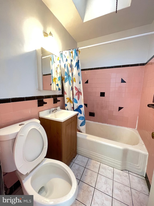 full bathroom featuring vanity, tile patterned floors, toilet, tile walls, and shower / tub combo