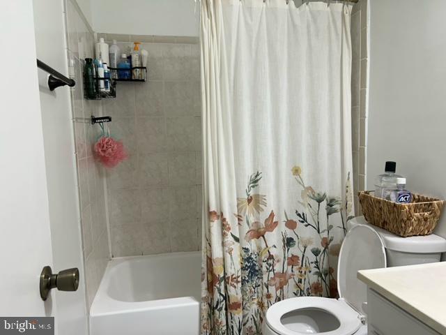 full bathroom with vanity, toilet, and shower / bath combo with shower curtain