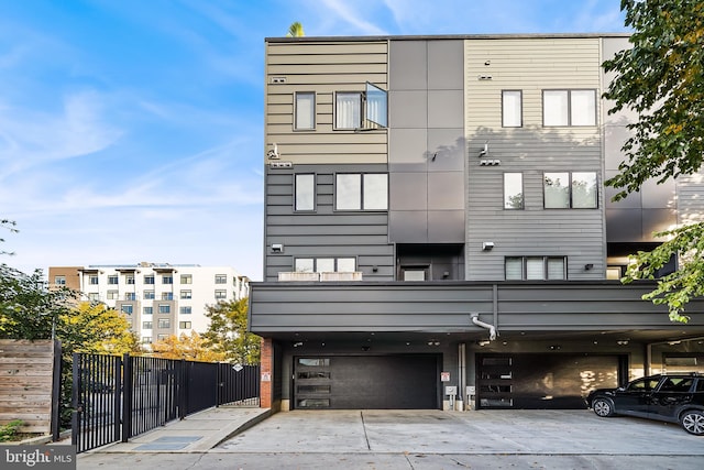 contemporary home featuring a garage and fence