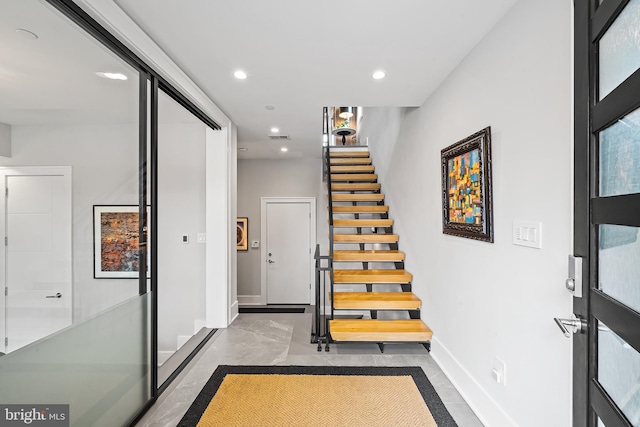 foyer entrance with recessed lighting, visible vents, baseboards, stairs, and finished concrete floors