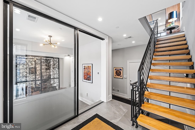 stairway featuring concrete flooring, recessed lighting, a notable chandelier, visible vents, and baseboards