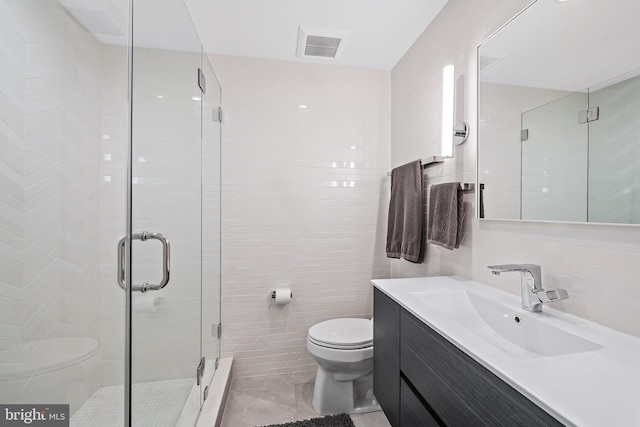 full bath featuring toilet, visible vents, vanity, tile walls, and a stall shower