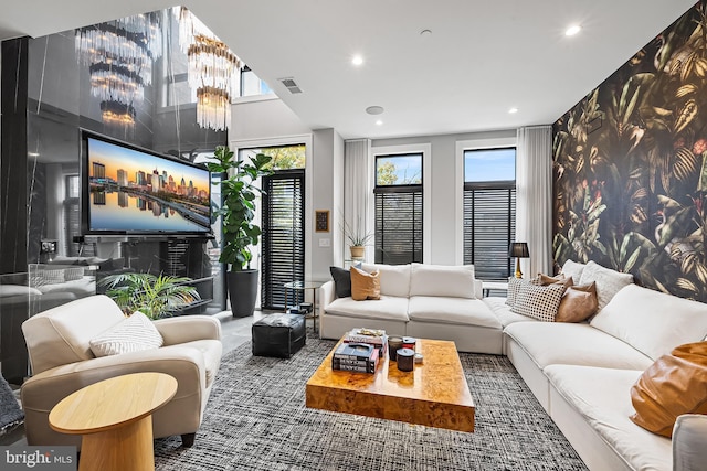 living room featuring an accent wall, recessed lighting, and visible vents