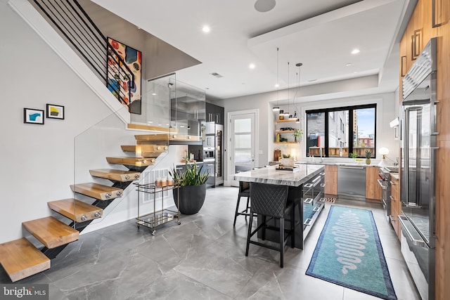 kitchen with a breakfast bar, a large island, open shelves, appliances with stainless steel finishes, and modern cabinets