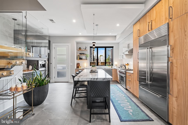 kitchen featuring under cabinet range hood, visible vents, high quality appliances, light stone countertops, and open shelves