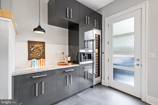 kitchen with dark cabinets, marble finish floor, light stone countertops, tasteful backsplash, and modern cabinets