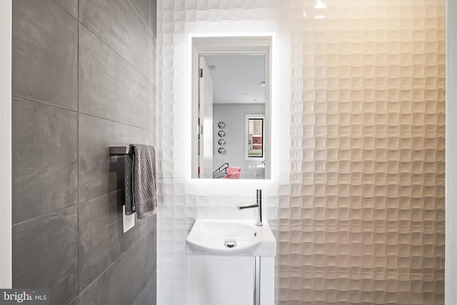 bathroom with tile walls and vanity