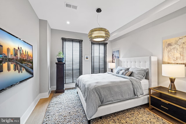 bedroom featuring baseboards, visible vents, wood finished floors, and recessed lighting