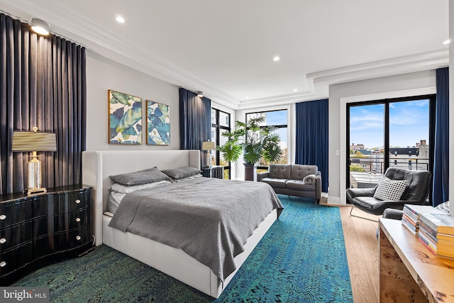 bedroom with access to outside, multiple windows, wood finished floors, and recessed lighting