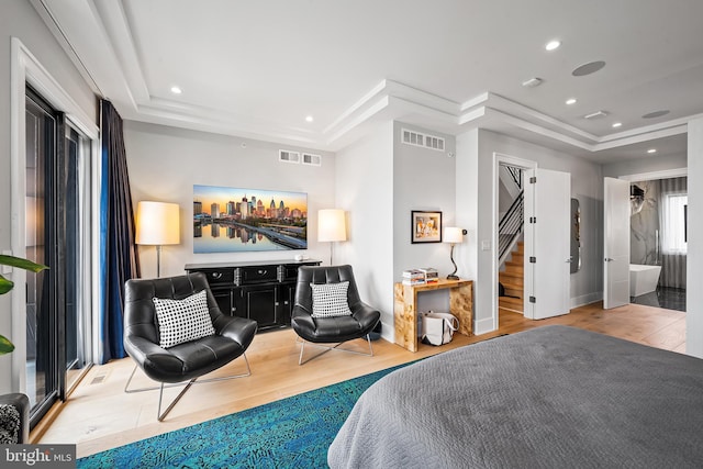 bedroom with a tray ceiling, visible vents, recessed lighting, and wood finished floors