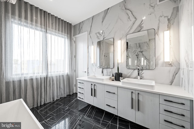 full bath featuring double vanity, a sink, and tile walls