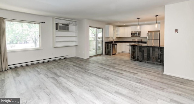 kitchen featuring pendant lighting, a baseboard heating unit, white cabinets, light wood-type flooring, and stainless steel appliances