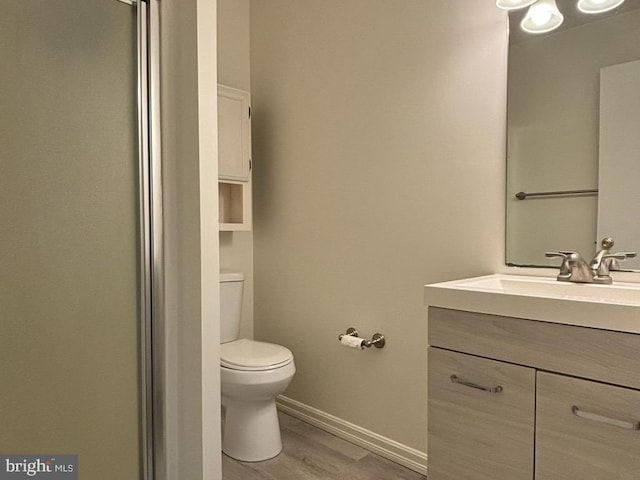 bathroom with hardwood / wood-style floors, vanity, and toilet