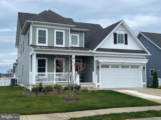 view of front of home with central air condition unit, covered porch, a front yard, and a garage