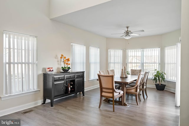 dining space with ceiling fan and light wood-type flooring