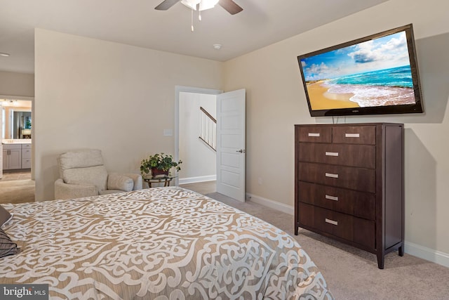 bedroom featuring light carpet, ensuite bath, and ceiling fan